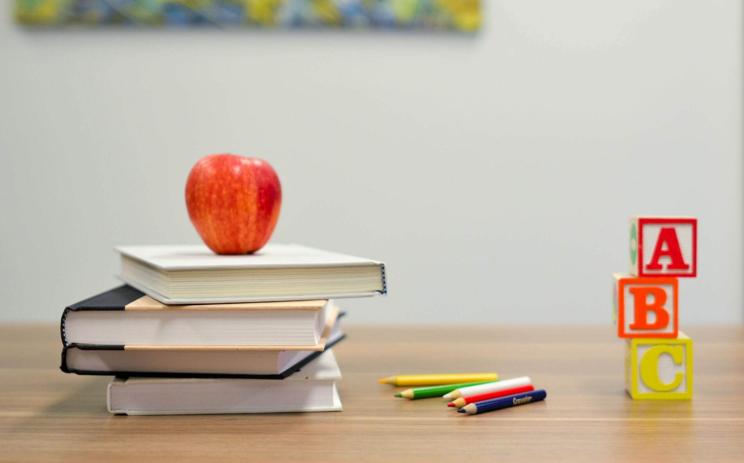 stack of books and apple teachers desk